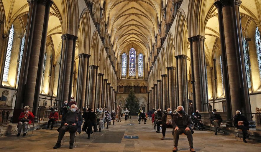 People sit and relax after receiving their Pfizer-BioNTech vaccination at Salisbury Cathedral in Salisbury, England, Wednesday, Jan. 20, 2021. Salisbury Cathedral opened its doors for the second time as a venue for the Sarum South Primary Care Network COVID-19 Local Vaccination Service. (AP Photo/Frank Augstein)