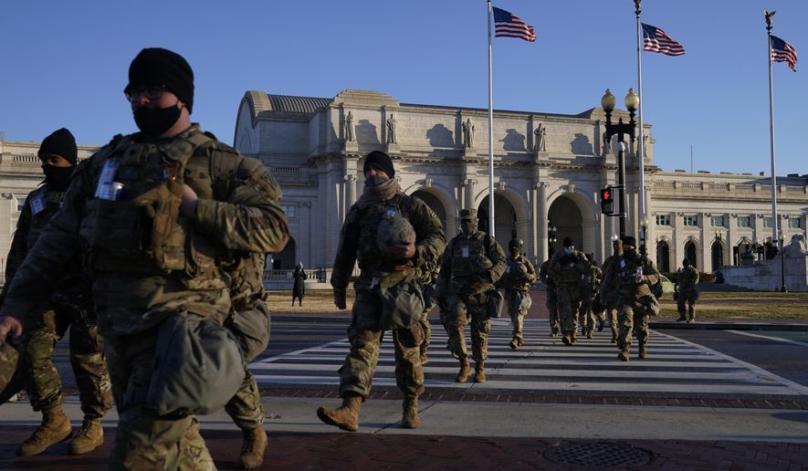 National Guards walk from Union Station to the U.S. Capitol as events get underway for President-elect Joe Biden&#39;s inauguration ceremony, Wednesday, Jan. 20, 2021, in Washington. (AP Photo/John Minchillo) ** FILE **