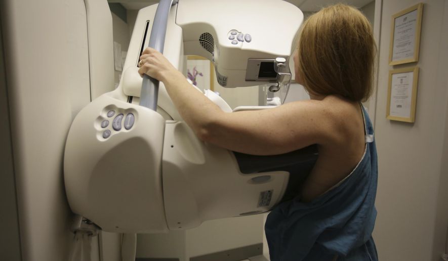 FILE - In this May 22, 2015 photo, a woman gets a mammogram at the University of Michigan Cancer Center in Ann Arbor, Mich. Two large studies, published Wednesday, Jan. 20, 2021, by the New England Journal of Medicine, give a much sharper picture of which inherited mutations raise the risk of breast cancer for women without a family history of the disease, and how common these flawed genes are in the general population. Doctors say the results can help women make better decisions about screening, preventive surgery or other steps. (Kimberly P. Mitchell/Detroit Free Press via AP, File)