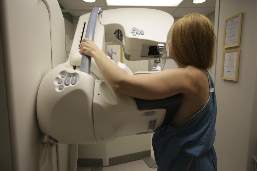 FILE - In this May 22, 2015 photo, a woman gets a mammogram at the University of Michigan Cancer Center in Ann Arbor, Mich. Two large studies, published Wednesday, Jan. 20, 2021, by the New England Journal of Medicine, give a much sharper picture of which inherited mutations raise the risk of breast cancer for women without a family history of the disease, and how common these flawed genes are in the general population. Doctors say the results can help women make better decisions about screening, preventive surgery or other steps. (Kimberly P. Mitchell/Detroit Free Press via AP, File)