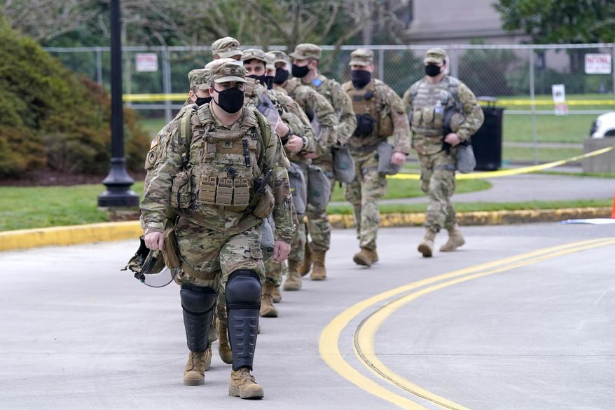 Washington National Guard members walk in formation away from the Legislative Building, Wednesday, Jan. 20, 2021, at the Capitol in Olympia, Wash. Members of the Guard and Washington State Patrol troopers have been in place all week on the campus providing security against possible protests connected with the inauguration of President Joe Biden and the departure of former President Donald Trump in Washington, D.C.. (AP Photo/Ted S. Warren)