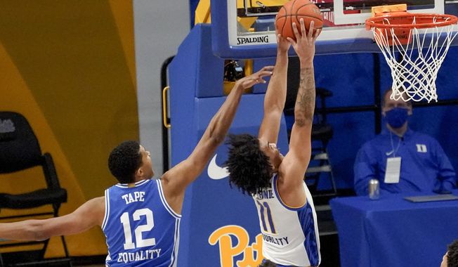 Pittsburgh&#x27;s Justin Champagnie (11) dunks after getting by Duke&#x27;s Patrick Tape (12) during the first half of an NCAA college basketball game, Tuesday, Jan. 19, 2021, in Pittsburgh. (AP Photo/Keith Srakocic)
