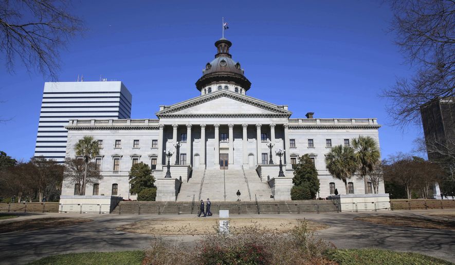 Police officers are the only people seen at the South Carolina Statehouse on Wednesday, Jan. 20, 2021, in Columbia, South Carolina. The capitol was closed for safety concerns for President Joe Biden's inauguration. (AP Photo/Jeffrey Collins)