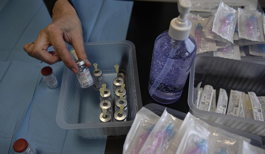 A health worker prepares Moderna coronavirus vaccines before vaccinating staff health workers at Clinica Universitaria, in Pamplona, northern Spain, Wednesday, Jan. 20, 2021. (AP Photo/Alvaro Barrientos)