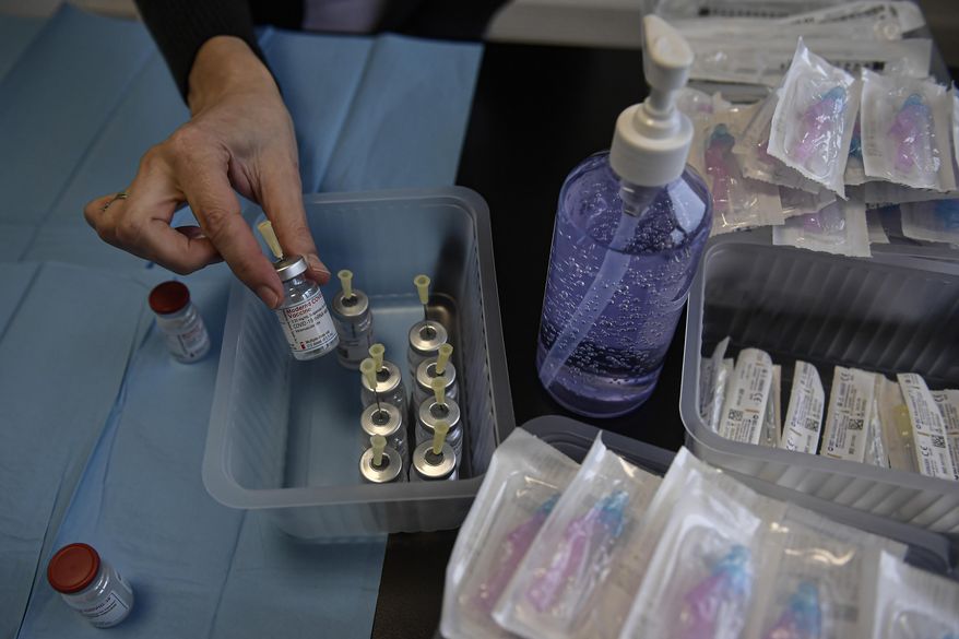A health worker prepares Moderna coronavirus vaccines before vaccinating staff health workers at Clinica Universitaria, in Pamplona, northern Spain, Wednesday, Jan. 20, 2021. (AP Photo/Alvaro Barrientos)