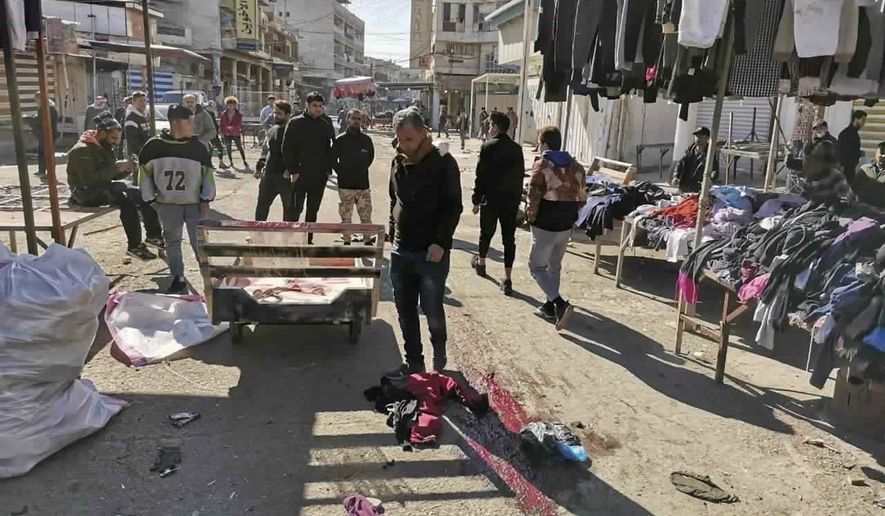 People and security forces gather at the site of a deadly bomb attack in Baghdad&#x27;s bustling commercial area, Iraq, Thursday, Jan. 21, 2021. Twin suicide bombings hit Iraq&#x27;s capital Thursday killing and wounding civilians, police and state TV said. (AP Photo/Hadi Mizban)