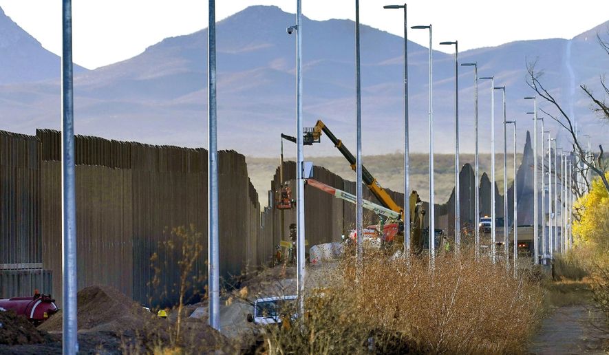 Crews construct a section of border wall in San Bernardino National Wildlife Refuge, Tuesday, Dec. 8, 2020, in Douglas, Ariz. President Biden on Wednesday ordered a &amp;quot;pause&amp;quot; on all wall construction within a week, one of 17 executive edicts issued on his first day in office, including six dealing with immigration. The order leaves projects across the border unfinished and under contract after Trump worked feverishly last year to reach 450 miles, a goal he announced was achieved eight days before leaving office. (AP Photo/Matt York)