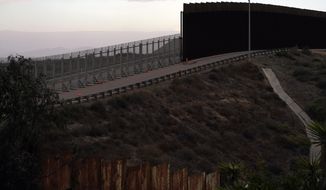 An incomplete secondary wall stands alongside the previous version near where the border separating Tijuana, Mexico, and San Diego meets the Pacific Ocean Tuesday, Jan. 19, 2021, in Tijuana, Mexico. In the days before Joe Biden became president, construction crews worked quickly to finish Donald Trump&#x27;s wall at an iconic cross-border park overlooking the Pacific Ocean that then-first lady Pat Nixon inaugurated in 1971 as symbol of international friendship. (AP Photo/Gregory Bull)