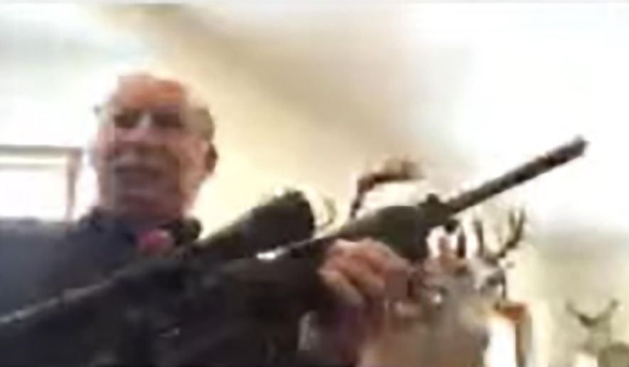 In this screen grab taken from a Zoom meeting provided by the Grand Traverse County Board of Commissioners, Grand Traverse County Commissioner Ron Clous holds a rifle at his home during a county commissioner meeting Wednesday, Jan. 20, 2021, in Michigan. Clous displayed the rifle during the online meeting in response to a citizen&#39;s comments about a far-right extremist group, drawing backlash from some local residents. (Grand Traverse County Board of Commissioners via AP)