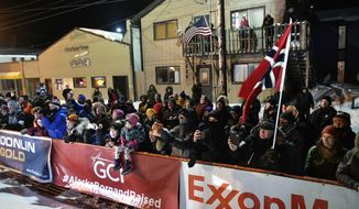 FILE - In this March 18, 2020, file photo, a crowd standing behind ExxonMobile signage watches as Thomas Waerner, of Norway, arrives in Nome, Alaska to win the Iditarod Trail Sled Dog Race. The world&#39;s most famous sled dog race has lost another major sponsor as the Iditarod prepares for a scaled-back version of this year&#39;s race because of the pandemic, officials said Thursday, Jan. 21, 2021. ExxonMobil confirmed to The Associated Press that the oil giant will drop its sponsorship of the race. (Marc Lester/Anchorage Daily News via AP, File)