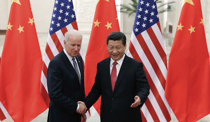 In this Dec. 4, 2013, file photo, Chinese President Xi Jinping, right, shakes hands with then U.S. Vice President Joe Biden as they pose for photos at the Great Hall of the People in Beijing. (AP Photo/Lintao Zhang, Pool, File)