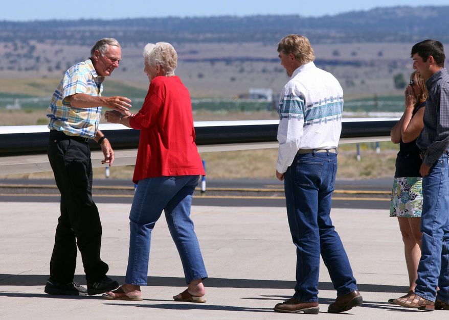 FILE - In this July 11, 2018, file photo, rancher Dwight Hammond Jr., left, is embraced by his wife, Susie Hammond, after arriving by private jet at the Burns Municipal Airport in Burns, Ore. Hammond and his son Steven, convicted of intentionally setting fires on public land in Oregon, were pardoned by President Donald Trump. The U.S. Bureau of Land Management in the final days of the Trump administration issued a grazing permit to Oregon ranchers whose imprisonment sparked the 2016 armed takeover of a federal wildlife refuge by right-wing extremists. (Beth Nakamura/The Oregonian via AP, File)