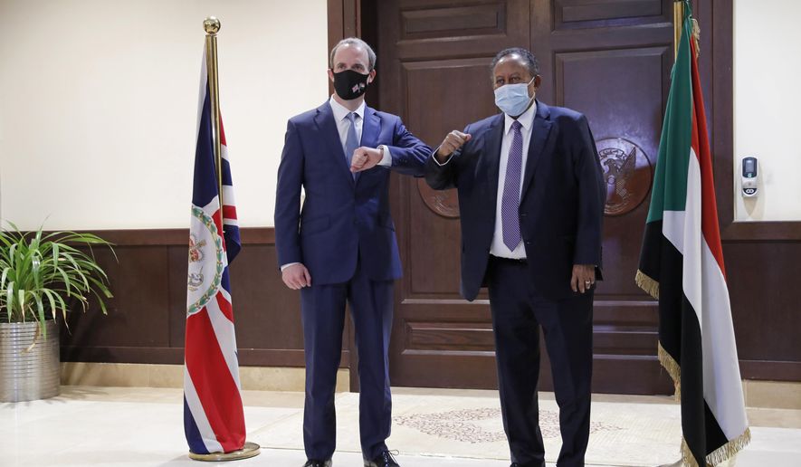 Sudanese Prime MInister Abdullah Hamdok, right, bumps elbows with British Foreign Secretary, Dominic Raab in the Cabinet Building, in Khartoum, Sudan, Thursday, Jan. 21, 2021. Raab was in the Sudanese capital Thursday to discuss bilateral relations and tensions along the border with Ethiopia, Sudan&#39;s state news agency reported. (AP Photo)