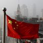 A Chinese national flag flutters against the office buildings in Shanghai, China. (AP Photo/Andy Wong) **FILE**