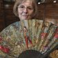 Anne Hoguet, 74, fan maker and director of the hand fan-making museum poses with a wood roasted hand fan representing a falcon hunt, gouache painting g on paper from 1880 at the museum in Paris, Wednesday, Jan. 20, 2021. Just like the leaves of its gilded fans, France&#x27;s storied hand fan-making museum could fold up and vanish. The splendid Musee de l&#x27;Eventail in Paris, a classed historical monument, is the culture world&#x27;s latest coronavirus victim. (AP Photo/Michel Euler)