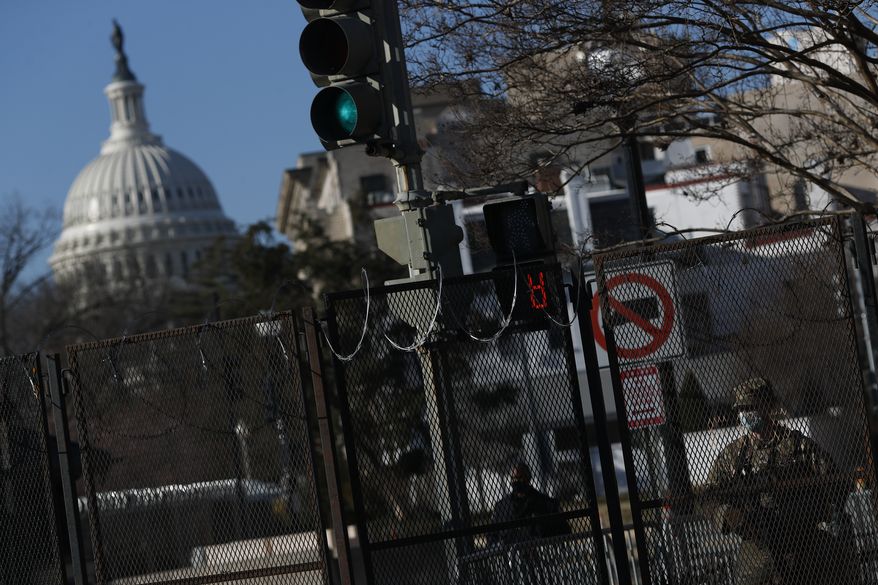 National Guard troops and Capitol Police stand guard at the security perimeter around the Capitol, two days after the inauguration of President Joe Bidenon Friday, Jan. 22, 2021 in Washington.(AP Photo/Rebecca Blackwell)