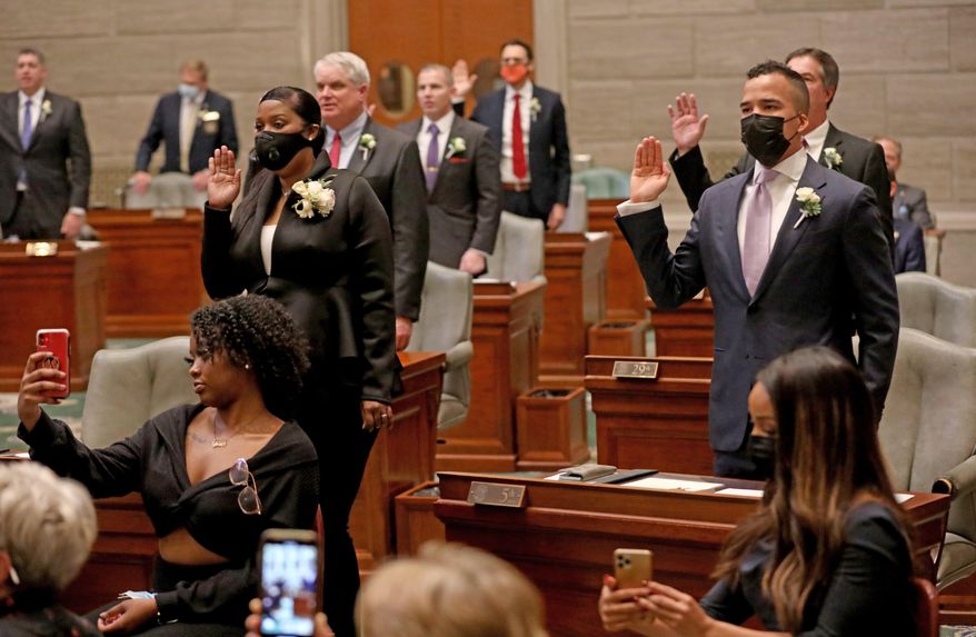 Democrats Angela Walton Mosley of Florissant, left, and Steven Roberts Jr. of St. Louis, right, raise their hands as they are sworn in as state senators on Wednesday, Jan. 6, 2021, at the Capitol in Jefferson City, Mo. (Laurie Skrivan/St. Louis Post-Dispatch via AP)