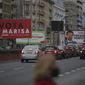 Cars drive past election campaign billboards for presidential candidates Marisa Matias, left, and Andre Ventura, right, in Lisbon, Tuesday, Jan. 19, 2021. Portugal holds a presidential election on Sunday, Jan. 24, 2021 and the moderate incumbent candidate is widely seen as the sure winner. But an intriguing question for many Portuguese is how well a brash new populist challenger fares in the ballot. Mainstream populism is a novelty in Portugal. (AP Photo/Armando Franca)