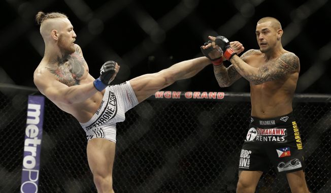 FILE - In this Sept. 27, 2014, file photo, Conor McGregor, left, kicks Dustin Poirier during their mixed martial arts bout in Las Vegas. McGregor returns from a year-long layoff for a rematch against Poirier in the promotions&#x27;s first pay-per-view of the year, at UFC 257 on Jan. 24 at Abu Dhabi. (AP Photo/John Locher, File)