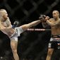 FILE - In this Sept. 27, 2014, file photo, Conor McGregor, left, kicks Dustin Poirier during their mixed martial arts bout in Las Vegas. McGregor returns from a year-long layoff for a rematch against Poirier in the promotions&#39;s first pay-per-view of the year, at UFC 257 on Jan. 24 at Abu Dhabi. (AP Photo/John Locher, File)