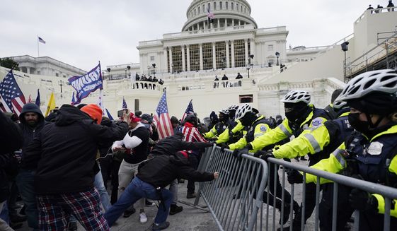 FILE - In this Wednesday, Jan. 6, 2021 file photo, Trump supporters try to break through a police barrier at the Capitol in Washington. Right-wing extremism has previously mostly played out in isolated pockets of America or in smaller cities. In contrast, the deadly attack by rioters on the U.S. Capitol targeted the very heart of government. It brought together members of disparate groups, creating the opportunity for extremists to establish links with each other. (AP Photo/Julio Cortez, File)