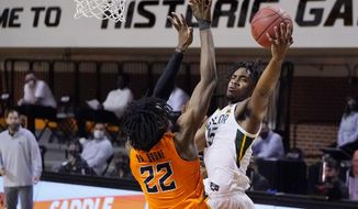 Baylor guard Davion Mitchell, right, shoots as Oklahoma State forward Kalib Boone (22) defends in the first half of an NCAA college basketball game Saturday, Jan. 23, 2021, in Stillwater, Okla. (AP Photo/Sue Ogrocki)
