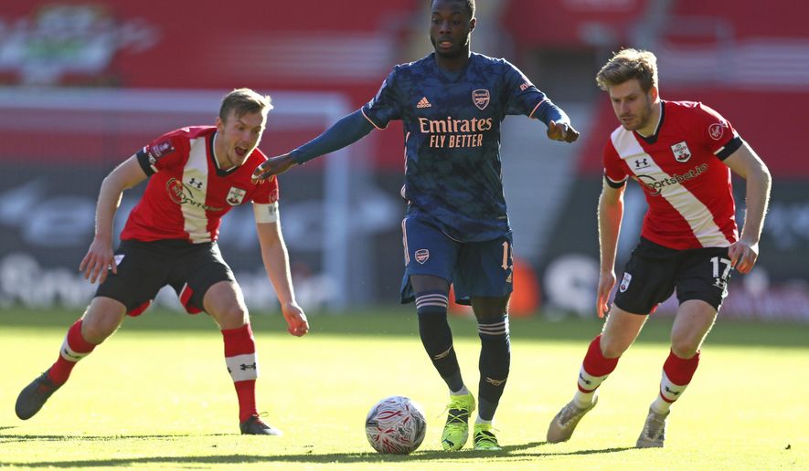 Arsenal&#39;s Nicolas Pepe, center, battles for the ball with Southampton&#39;s James Ward-Prowse, left, and Stuart Armstrong during the Emirates FA Cup fourth round soccer match at St. Mary&#39;s Stadium, Southampton, England, Saturday Jan. 23, 2021. (Catherine Ivill/PA via AP)