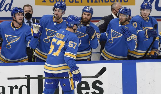 St. Louis Blues&#x27; David Perron (57) is congratulated by teammates after scoring a goal against the Los Angeles Kings during the second period of an NHL hockey game Saturday, Jan. 23, 2021, in St. Louis. (AP Photo/Joe Puetz)