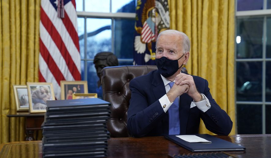 President Joe Biden waits to sign his first executive order in the Oval Office of the White House in Washington on Jan. 20, 2021. (AP Photo/Evan Vucci) **FILE**