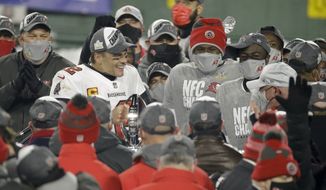 Tampa Bay Buccaneers quarterback Tom Brady (12) holds the championship trophy after winning the NFC championship NFL football game against the Green Bay Packers in Green Bay, Wis., Sunday, Jan. 24, 2021. The Buccaneers defeated the Packers 31-26 to advance to the Super Bowl. (AP Photo/Mike Roemer)