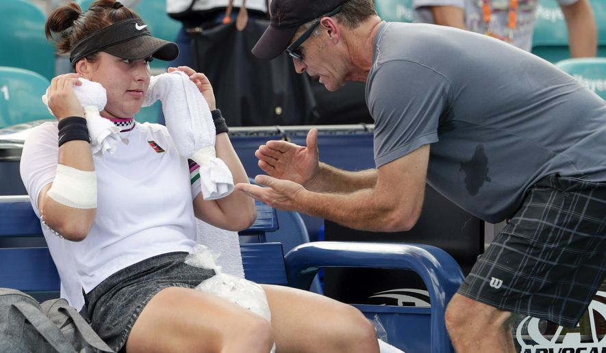 FILE - In this March 21, 2019 file photo, Bianca Andreescu, of Canada, left, talks with her coach Sylvain Bruneau during her match against Irina Camelia Begu, of Romania, at the Miami Open tennis tournament in Miami Gardens, Fla. Bruneau has released a statement, Sunday, Jan. 17, 2021, saying he was the positive coronavirus case aboard the flight from Abu Dhabi to Melbourne and he had followed all protocols and procedures, including producing a negative test within 72 hours before the flight departure and has "no idea how I might have contracted the virus." (AP Photo/Lynne Sladky, File)