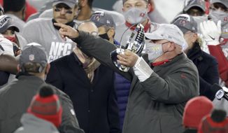 Tampa Bay Buccaneers head coach Bruce Arians holds the championship trophy after winning the NFC championship NFL football game against the Green Bay Packers in Green Bay, Wis., Sunday, Jan. 24, 2021. The Buccaneers defeated the Packers 31-26 to advance to the Super Bowl. (AP Photo/Matt Ludtke)