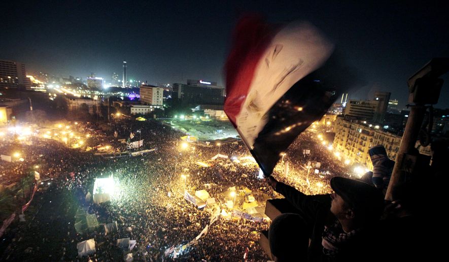 FILE - In this Jan. 25, 2012 file photo, people wave flags in Tahrir Square to mark the first anniversary of the popular uprising that led to the quick ouster of autocrat President Hosni Mubarak, in Cairo, Egypt. A decade later, thousands are estimated to have fled abroad to escape a state, headed by President Abdel Fattah el-Sissi, that is even more oppressive. (AP Photo/Amr Nabil, File)