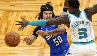 Orlando Magic guard Cole Anthony (50) passes the ball around Charlotte Hornets guard Terry Rozier (3) during the second half of an NBA basketball game, Sunday, Jan. 24, 2021, in Orlando, Fla. (AP Photo/John Raoux)