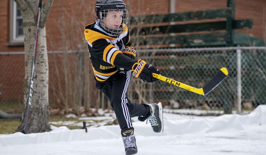 Bronson Jones, 10, practices hockey in his backyard on Monday, Jan. 11, 2021 in Battle Creek, Mich. The backyard ice rink was constructed by his father, Justin Jones.  (Alyssa Keown /Battle Creek Enquirer via AP)