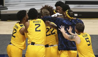 West Virginia players celebrate after defeating Texas Tech in an NCAA college basketball game Monday, Jan. 25, 2021, in Morgantown, W.Va. (AP Photo/Kathleen Batten)