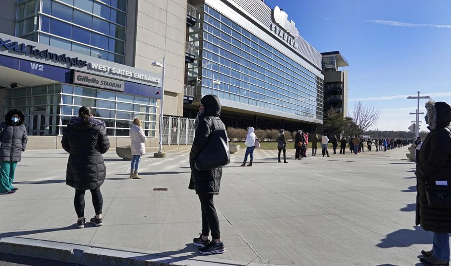 People wait in a socially distanced line to get their COVID-19 vaccinations at Gillette Stadium, Monday, Jan. 25, 2021, in Foxborough, Mass. (AP Photo/Elise Amendola)