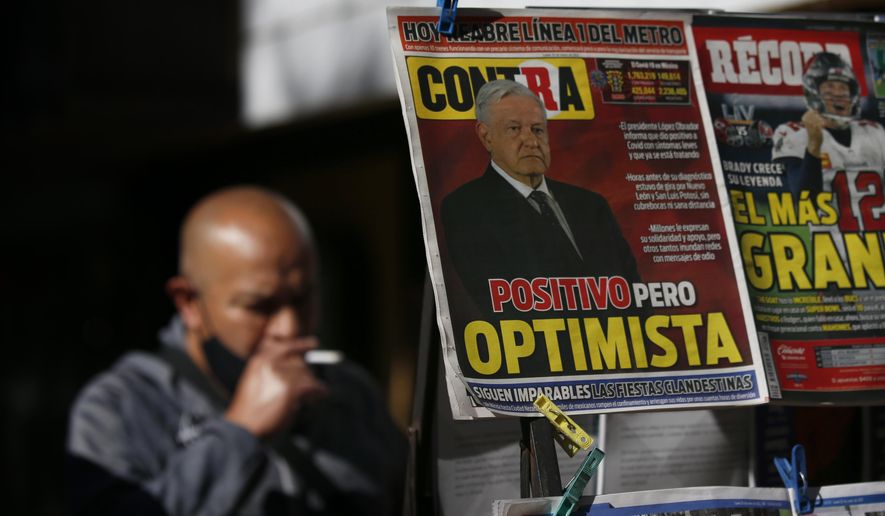 A newspaper's front page carries the Spanish headline "Positive but optimistic" for the story about Mexican President Andrés Manuel López Obrador having COVID-19 at a kiosk on Paseo de la Reforma in Mexico City, Monday, Jan. 25, 2021. López Obrador was working from isolation on Monday, Jan. 25, 2021, a day after announcing that he had tested positive for COVID-19, his interior secretary said. (AP Photo/Marco Ugarte)