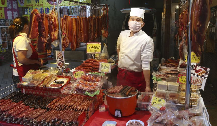 A vendor wears a face masks to help curb the spread of the coronavirus at his shop at a market in Taipei, Taiwan, Monday, Jan. 25, 2021. (AP Photo/Chiang Ying-ying)
