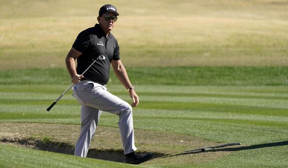 Phil Mickelson walks out from a bunker after hitting to the 17th green during the first round of The American Express golf tournament on the Nicklaus Tournament Course at PGA West Thursday, Jan. 21, 2021, in La Quinta, Calif. (AP Photo/Marcio Jose Sanchez)