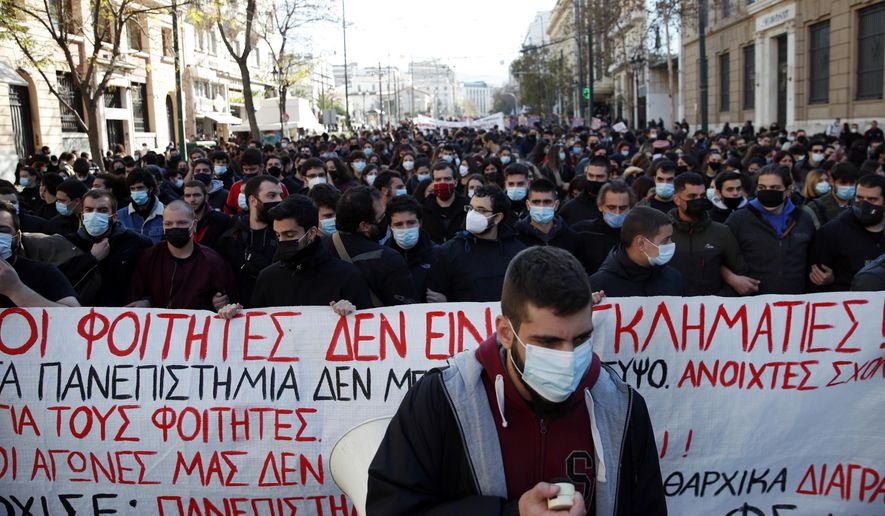 University students gather during a rally against educational reforms as the banner reads &amp;quot;The students are not criminals&amp;quot; in Athens, Thursday, Jan. 21, 2021. About 1,500 students took part in two separate protests against government&#x27;s plans to set up a state security division at university campuses and time limits set for the completion of degree courses. (AP Photo/Thanassis Stavrakis)