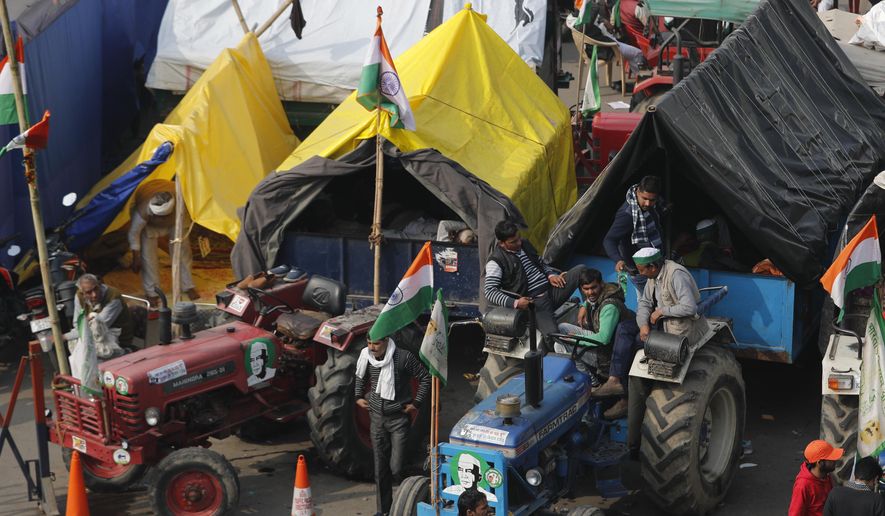 Indian farmers sit on their tractor after arriving at the Delhi-Uttar Pradesh border for Tuesday&#x27;s tractor rally in New Delhi, India, Monday, Jan. 25, 2021. (AP Photo/Manish Swarup)