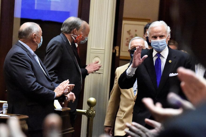South Carolina Gov. Henry McMaster, right, waves as he walks into the state House chamber for his State of the State address on Wednesday, Jan. 13, 2021, in Columbia, S.C. (AP Photo/Meg Kinnard)