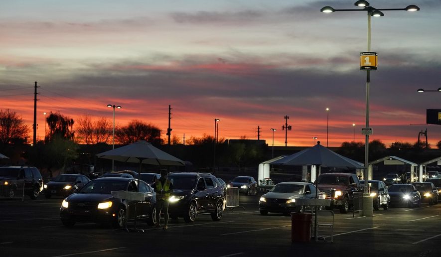 FILE - In this Jan. 12, 2021, file photo, vehicles line up so people can get their COVID-19 vaccination cards after being vaccinated in a pre-registered drive-thru in the parking lot of the State Farm Stadium in Glendale, Ariz. Arizona reported 4,748 additional known COVID-19 cases and 209 deaths on Tuesday, Jan. 26 the one-year anniversary of the announcement of the state&#x27;s first confirmed coronavirus case in the outbreak that has since claimed thousands of lives statewide. (AP Photo/Ross D. Franklin, File)