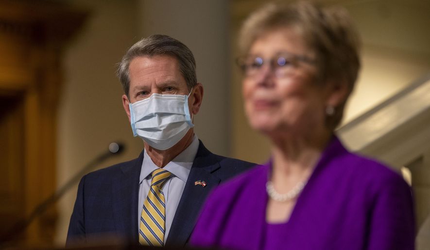 Dr. Kathleen Toomey, Commissioner of Georgia Department of Public Health, makes remarks as Georgia Gov. Brian Kemp listens during a COVID-19 update press conference at the Georgia State Capitol Building in Atlanta, Thursday, Jan. 21, 2021. (Alyssa Pointer/Atlanta Journal-Constitution via AP)