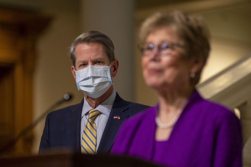 Dr. Kathleen Toomey, Commissioner of Georgia Department of Public Health, makes remarks as Georgia Gov. Brian Kemp listens during a COVID-19 update press conference at the Georgia State Capitol Building in Atlanta, Thursday, Jan. 21, 2021. (Alyssa Pointer/Atlanta Journal-Constitution via AP)