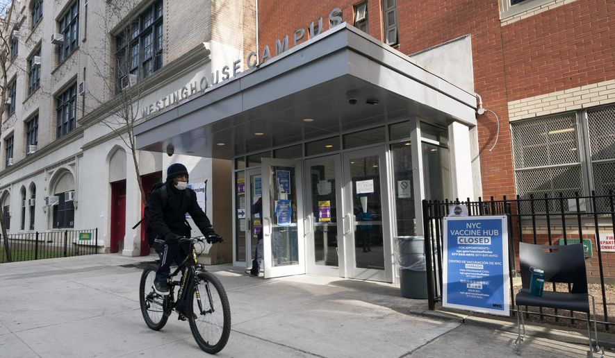 In this Jan. 21, 2021, photo, a cyclist passes a closed vaccination center at the George Westinghouse High School in New York. An increasing number of COVID-19 vaccination sites around the U.S. are canceling appointments because of vaccine shortages in a rollout so rife with confusion and unexplained bottlenecks. (AP Photo/Mark Lennihan) **FILE**