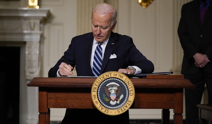 President Joe Biden signs an executive order on climate change, in the State Dining Room of the White House, Wednesday, Jan. 27, 2021, in Washington. (AP Photo/Evan Vucci)
