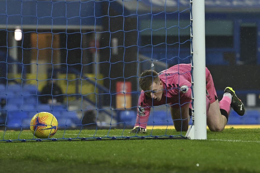 Everton's goalkeeper Jordan Pickford fals to same the shot by Leicester's Youri Tielemans who scored his side's opening goal during the English Premier League match between Everton and Leicester City at the Goodison Park stadium in Liverpool, England, Wednesday, Jan. 27, 2021. (Paul Ellis/Pool via AP)