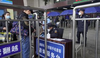 Travelers are screened before entering the Wuchang train station at the start of the annual Lunar New Year travel in Wuhan in central China&#39;s Hubei province on Thursday, Jan. 28, 2021. Efforts to dissuade Chinese from traveling for Lunar New Year appeared to be working as Beijing’s main train station was largely quiet and estimates of passenger totals were smaller than in past years.  (AP Photo/Ng Han Guan)